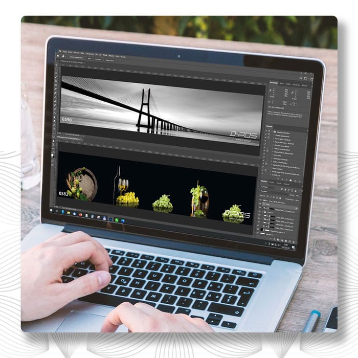 Dłonie przy laptopie z otwartym zdjęciem mostu w programie do obróbki grafiki