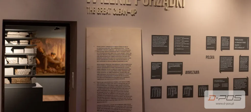 Druk ścienny z tekstem i ciemnymi planszami na jasnej ścianie wystawy