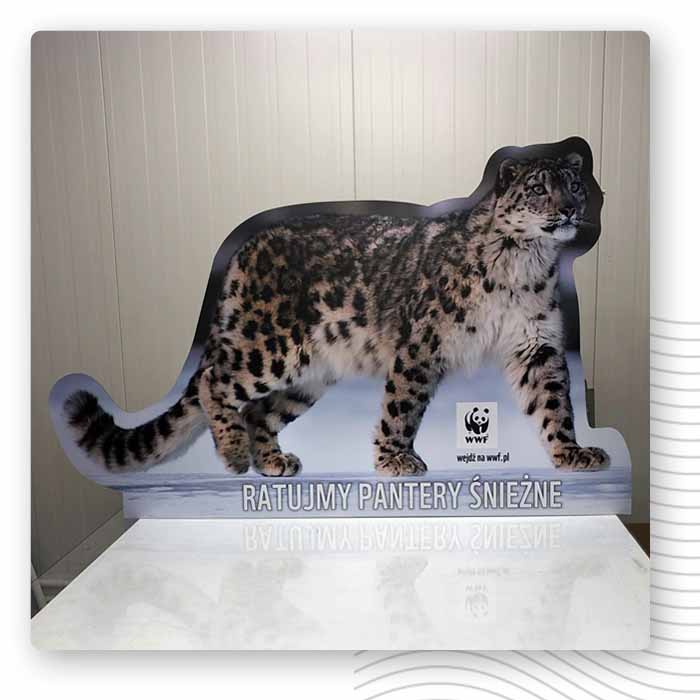 Wycięta figura pantery śnieżnej z logo WWF przy jasnej ścianie