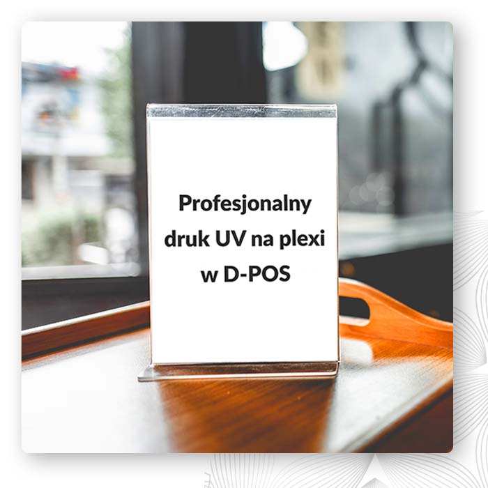 Przezroczysta tabliczka z plexi z nadrukiem UV i napisem D-POS na stole