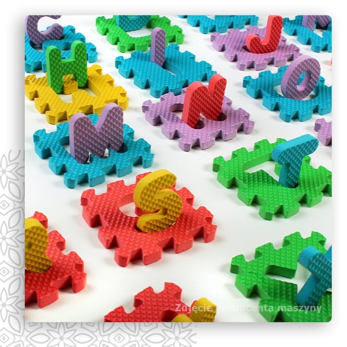 Kolorowe piankowe puzzle z literami i figurkami zwierząt na jasnym tle