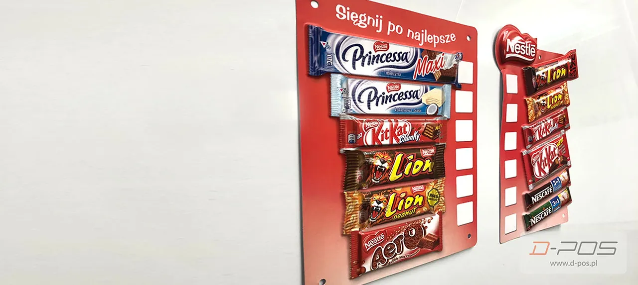 Czerwony ekspozytor półkowy z wafelkami Princessa i batonami Lion pod hasłem Sięgnij po najlepsze